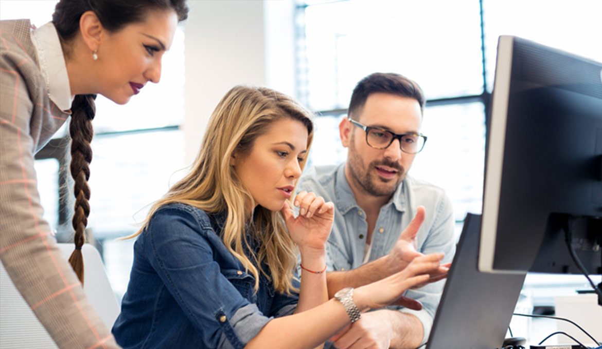 Young team of two women and a man collaborating as a team.