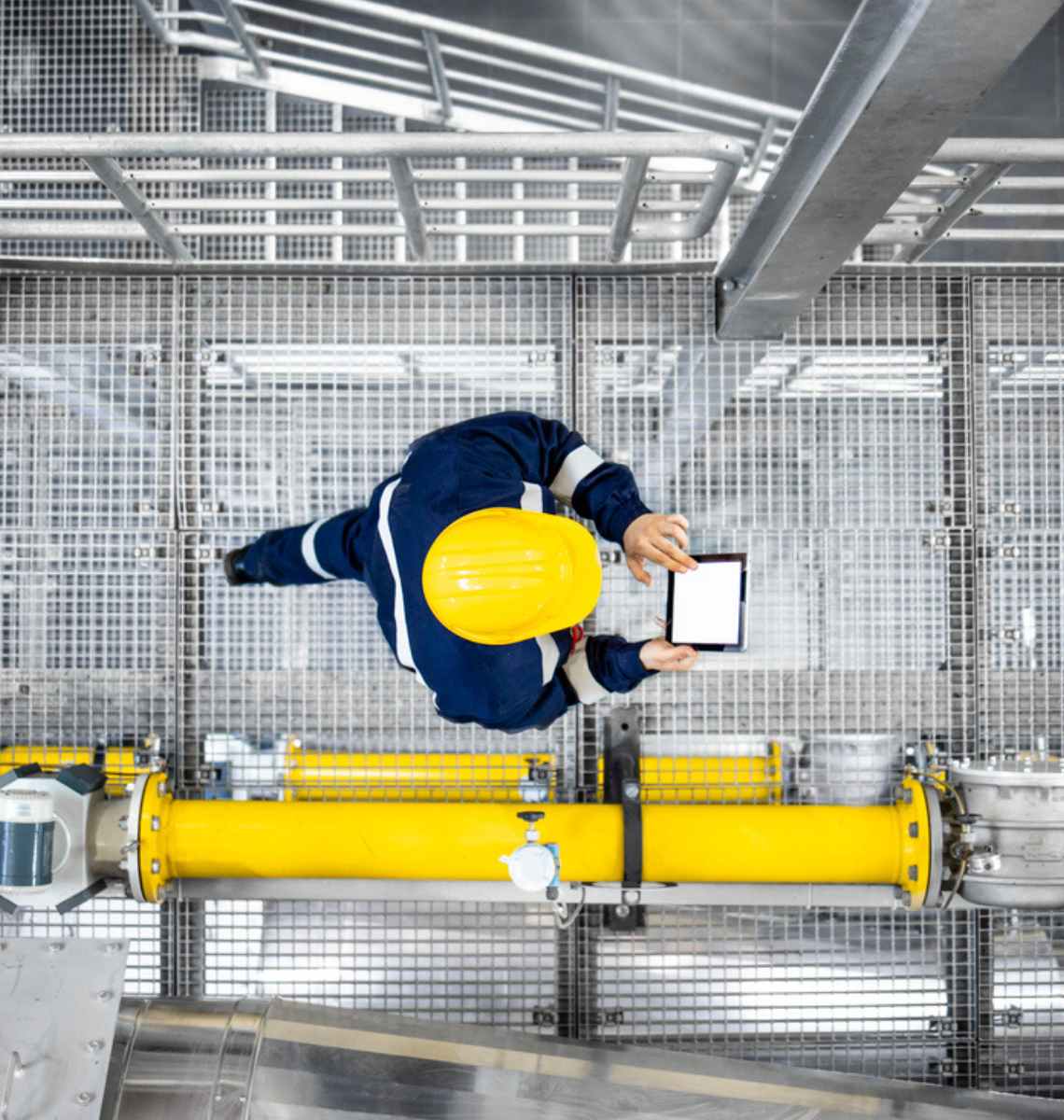 Aerial view of a maintenance worker walking through a facility conducting a digital inspection.