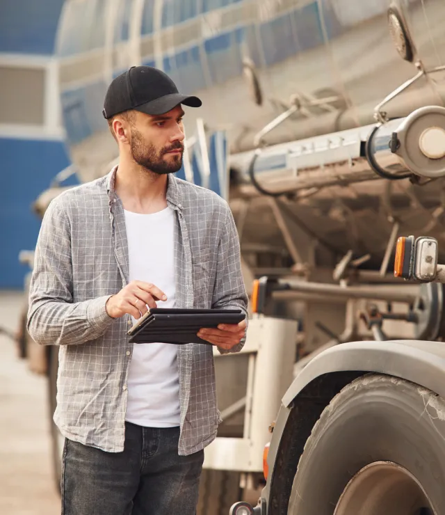 Driver using a tablet as he delivers a shipment of fuel.